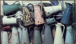 Arman. Acumulación de jarras. 1961. Jarras esmaltadas en vitrina de plexiglás, 83 x 142 x 142 cm.