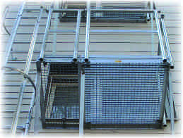 Escaleras verticales fijas Plataforma básica De acero zincado, con capa de rejilla y 2 canalones. Barandillas en un lado longitudinal y un lado frontal. Corresponde a DIN 14094.