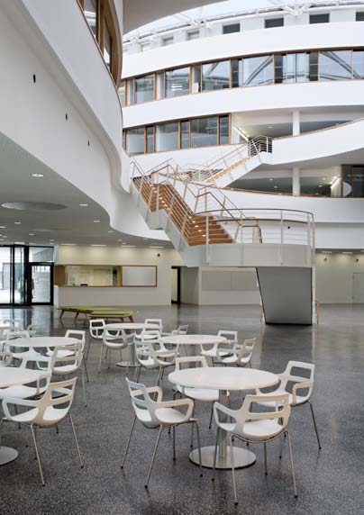 La silla patín fina en acabado blanco y la versión rectangular de la serie de mesas 3000 encajan elegantemente con el ambiente diáfano de la cafetería.