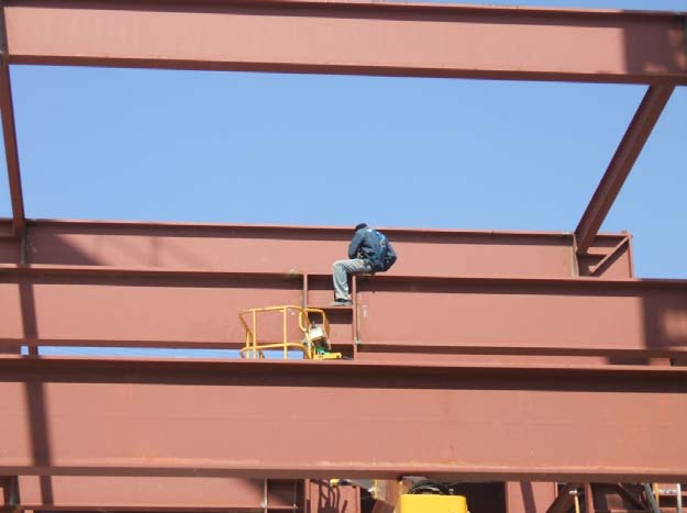 Fotografía 3. Soldadores trabajando desde plataformas elevadoras articuladas diesel. Estos riesgos aparecen principalmente: - En la descarga, elevación y transporte de materiales.