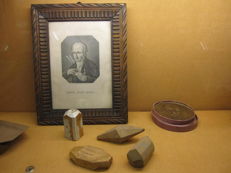 Figura 2. Modelos de arcilla (Romé de L Isle, XVIII) que simulan cristales cúbicos. Figura 3. Retrato de Haüy y algunos de sus modelos de madera (Musée de Minéralogie. Ecole des Mines de Paris).