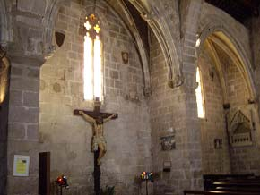 La fachada románica tiene una portada de arco de medio punto, formada por grandes dovelas, con tres arquivoltas en degradación y con una sencilla moldura exterior El techo decorado de esta iglesia se