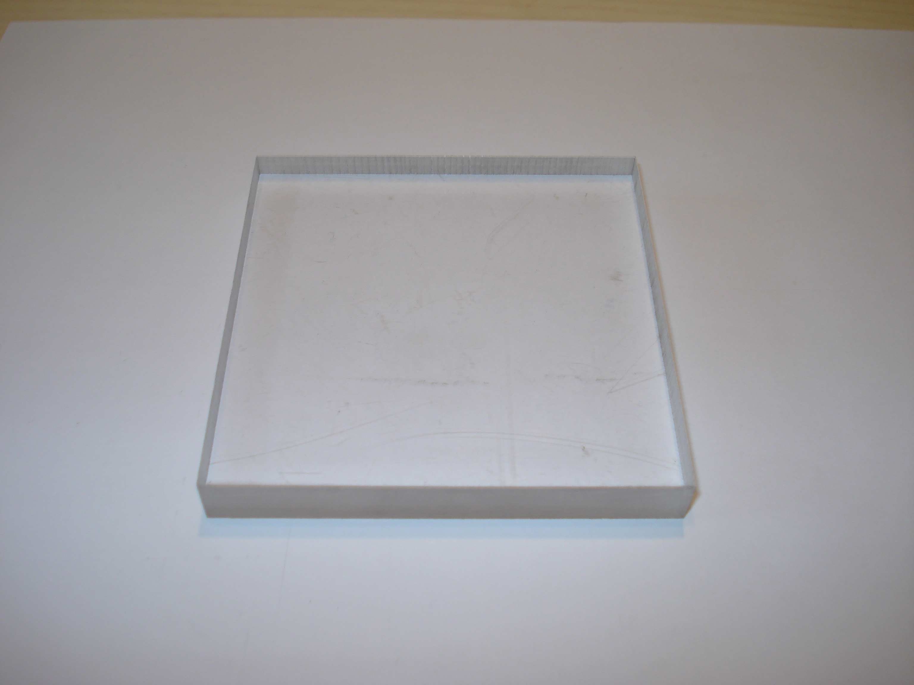 Figura 105: Detalle del corte de las tapas. Una vez cortadas las piezas, presentan el aspecto siguiente: Figura 106: Pieza de metacrilato de 80 x 80mm y 10mm de espesor.
