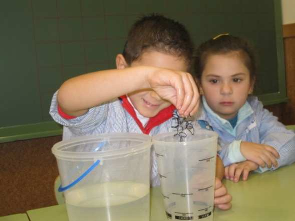 4 AÑOS Ania intenta coger el agua con la mano, pero sólo se moja las manos.