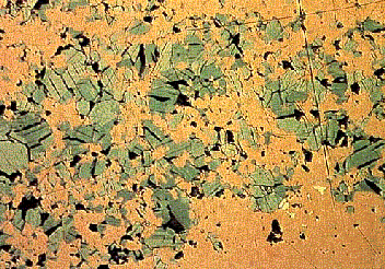 250 µm La bornita (cafe, abajo derecha) está en intercrecimiento con covellina (azul) que muestra buen clivaje, birreflectancia y pleocroismo de reflexión.