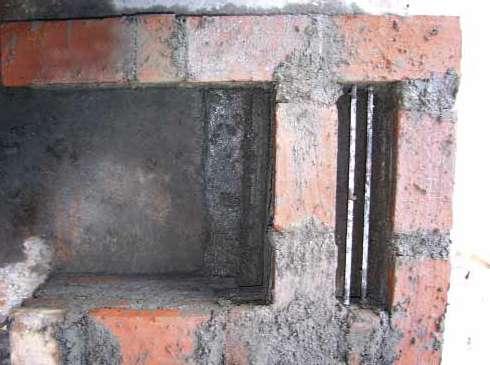 Vista frontal de la estufa con la cuarta hilada de ladrillos terminada y agujero de 4'' x 4'' construido.