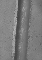 Imágenes obtenidas por microscopía óptica, del surco producido por el indentador en la prueba de rayado para películas de VN crecidas sobre aceros M2 a diferentes flujos de N 2 : (a) 1.5 sccm; (b) 2.