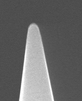 a b Figura 2.11 Imagen tomada con microscopía electrónica de barrido de (a) una punta de carburo de tungsteno de 60nm de radio y de (b) una punta de diamante rota y astillada durante una indentación.