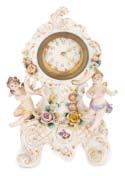 Pequeño reloj, de estilo francés, en porcelana esmaltada con angelitos a los