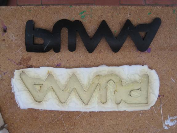 En la zona lisa pensé hacer el logo de Puma, así que recorte en un trozo de goma el logo y pegando las letras sobre un trozo de metacrilato las recubrí de silicona para hacer el molde, después de