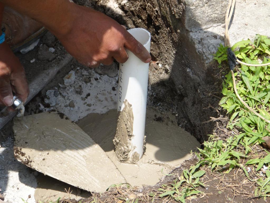 Paso 4: Metimos un tubo que atravesará toda la cisterna para poder conectar de arriba y de abajo. Lo rellenamos con un poco de cemento para sellar completamente el hoyo que hicimos.