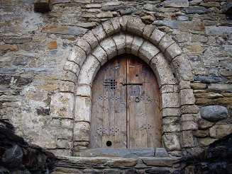 De pequeñas dimensiones también destacando el arco de punta de piedra a la entrada y sobre la fachada el