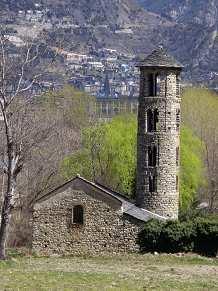 una cruz de piedra sobre el clave. 1) Torre de Santa Coloma.