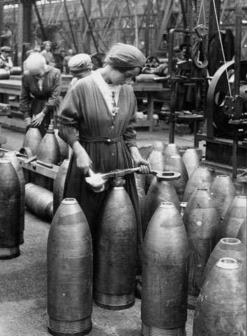 Army) Trabajadora preparando proyectiles en una fábrica,