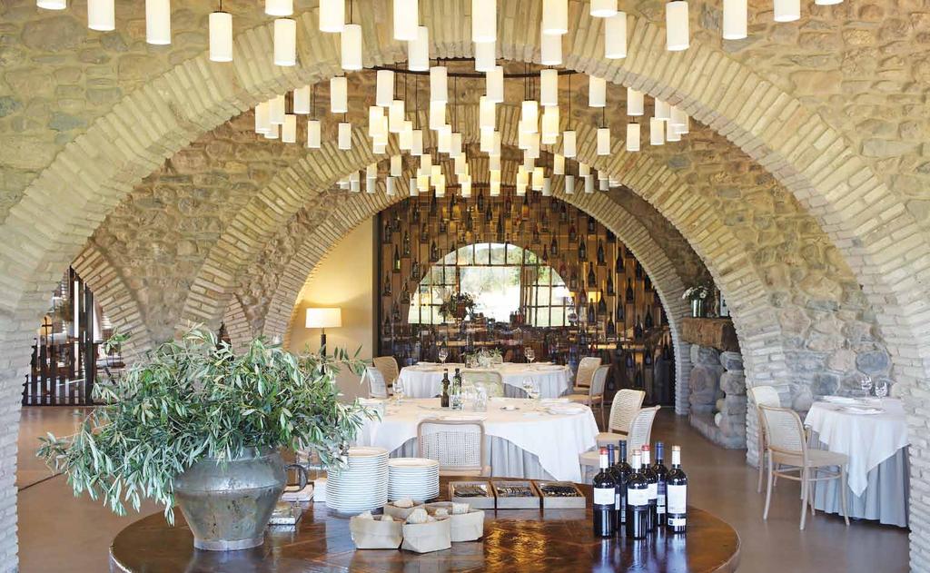 Un aspecto del restaurante del complejo hotelero donde se aprecia la calidad arquitectónica de los arcos de piedra que abren las estancias y a los que se adapta el local.