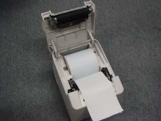 1) Encienda la impresora. 2) Sujete firmemente por los laterales que sobresalen de la tapa y levántelos para abrir la cubierta de la impresora.