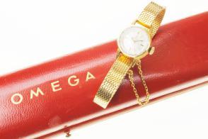 1259 Barcelona Reloj de cuerda, marca impresa OMEGA, para señora, con pulsera y cadenita de seguridad. Oro. Se adjunta estuche original. En funcionamiento.