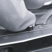 Apretar el gatillo del introductor de barras para que las mordazas se separen y puedan ajustarse al agujero de pivote de la barra