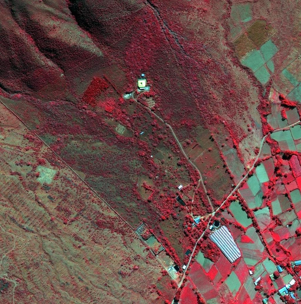 Foto 6: El predio Mollesnejta en temporada de sequía con colores falsos ; el color rojo indica un suelo con vigor y humedad; el canal de riego de la comunidad atraviesa la imagen desde la mitad del