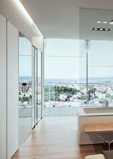Open space con vasca Style in Corian e mobili da terra serie Block, parete attrezzata con pensili Replay, piano lavabo Flat Corian e specchio Basic.