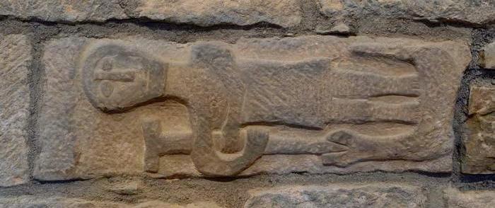 Fig. 2. Parroquial de Binacua. Pieza reutilizada. La escultura muestra a un personaje en pie sobre una bestia serpentiforme a la que clava en la boca un bastón en forma de tau.