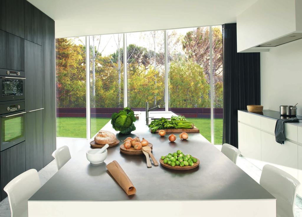 142 ARQUITECTURA Y DISEÑO Cocina abierta al paisaje natural. El mobiliario integral es un diseño de Wilfra & IDE.