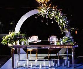 Montaje especial con sillas blancas, cintas de color a elección y mesa vestida en blanco. Arreglo de flores naturales para la mesa de Juez o Ministro (flores locales y de temporada).