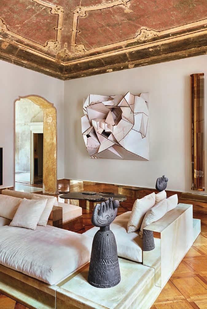 En el salón, sofás de resina, fibra de vidrio y lino, mesita y lámpara de neón de Vincenzo y escultura de cartón