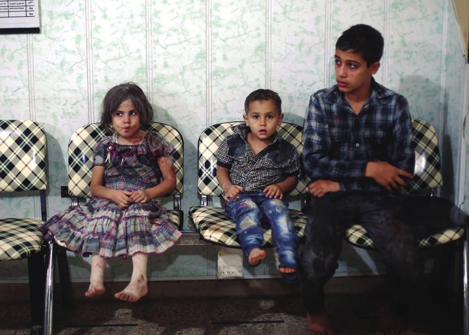Arriba, unos niños esperan para ser atendidos en la ciudad siria de Duma (se calcula en cerca de medio millón los muertos desde 2011).