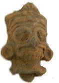 Córdoba Figurilla en barro representada con anteojeras, nariz, bigotera, dos colmillos, orejeras y tocado.