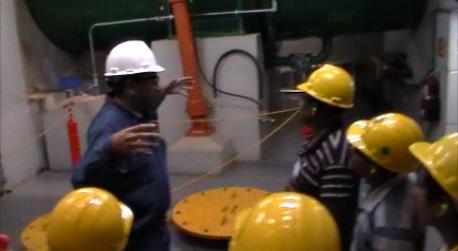 En esta imagen se observa a uno de los técnicos que operan la central, explicando el funcionamiento de alguno de los equipos que se encuentran dentro de la central hidroeléctrica El
