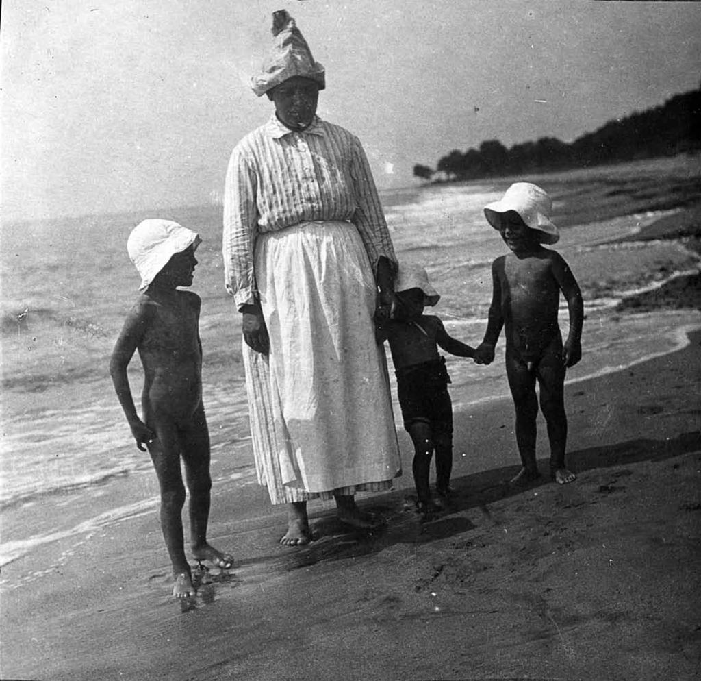 Tres xiquets amb la dida, a la platja Cap a 1930 Arxiu Municipal de