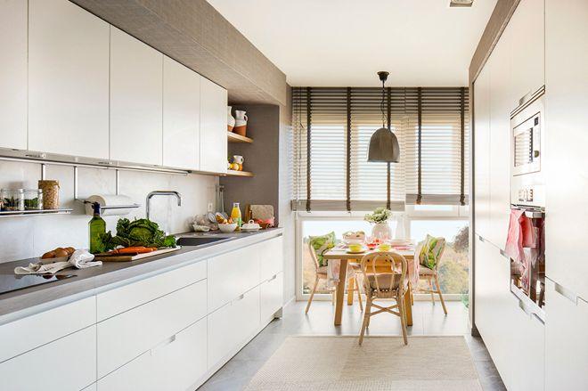 La cocina se conecta visualmente con el recibidor gracias a una ventana; además, se ha colocado una puerta acristalada de suelo a techo que deja pasar la luz natural.