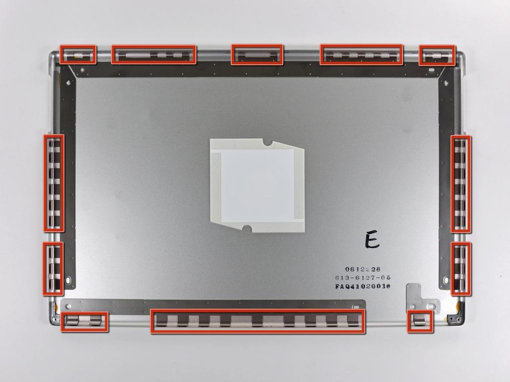 Paso 2 La imagen de la izquierda (panel trasero ya eliminado) muestra las ubicaciones de los ganchos de metal (en rojo) que se acoplan en el marco de la pantalla frontal.
