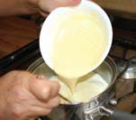 raspadura de naranja 108 Con un batidor de globo blanquear* las yemas con la mitad del azúcar. Poner la leche junto con el jugo de naranja y la otra mitad del azúcar en la olla a fuego bajo.