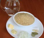 Saltear la cebolla con la mantequilla; añadir el ajo sin dejar de mover y el arroz, la sal y la pimienta.