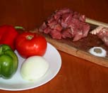 Insertar en los palitos de brocheta secuencias de carne, cebolla, tocino, pimiento y tomate. Agregar sal y pimienta.