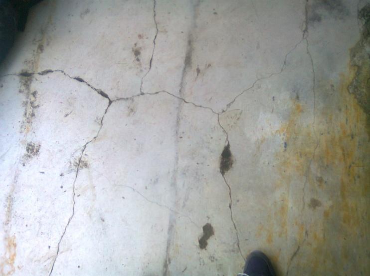 Grietas en el piso ubicadas en el antejardín de la vivienda causadas por las condiciones que tiene el terreno en la