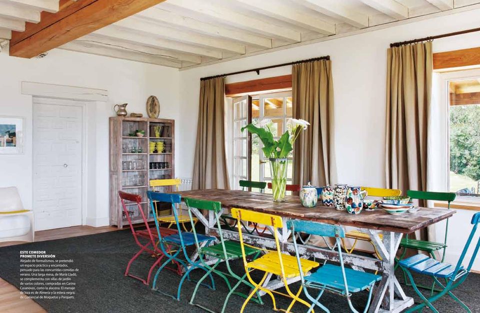 Una larga mesa, de María Lladó, se complementa con sillas de jardín de varios colores, compradas en
