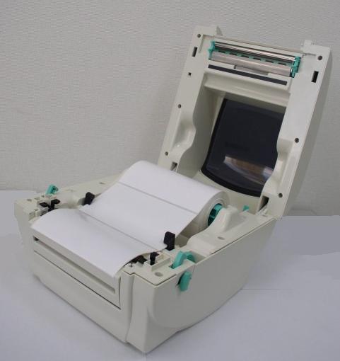 Abra la tapa superior de la impresora, soltando las palancas verdes de apertura de la tapa superior que se encuentran a ambos lados de la impresora y levantando la tapa superior. 3.