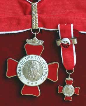 La Insignia Gran-Cruz Cinta roja con bordes blancos, con roseta y medalla, placa, miniatura, barreta y botón.