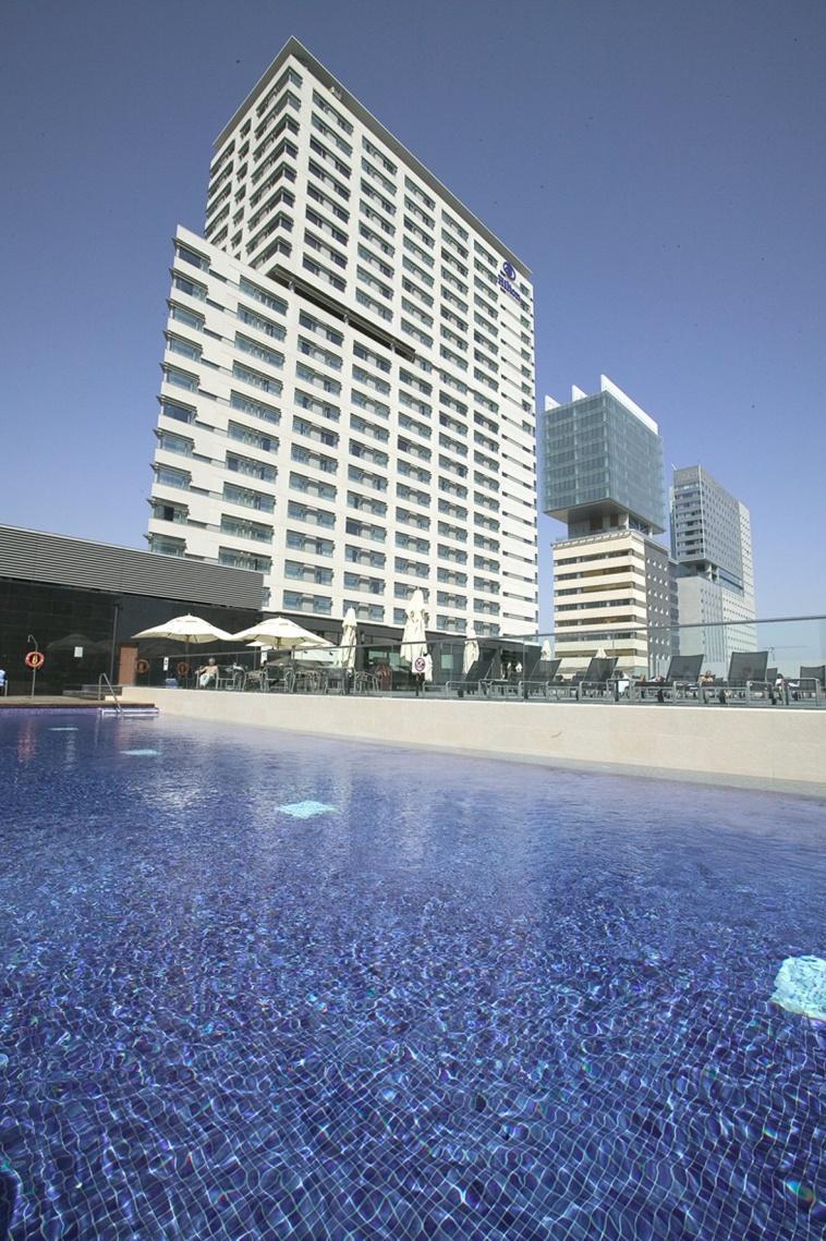 Hilton Diagonal Mar Barcelona Contemple la vista al mar desde la piscina al aire libre o del Executive Lounge del hotel
