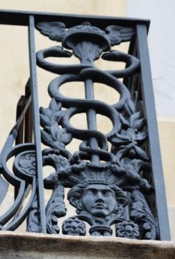 També està present al llarg dels balcons que són similars als del carrer de la Ciutat, a les cantonades també hi ha representat un caduceu amb un rostre associat als indians.