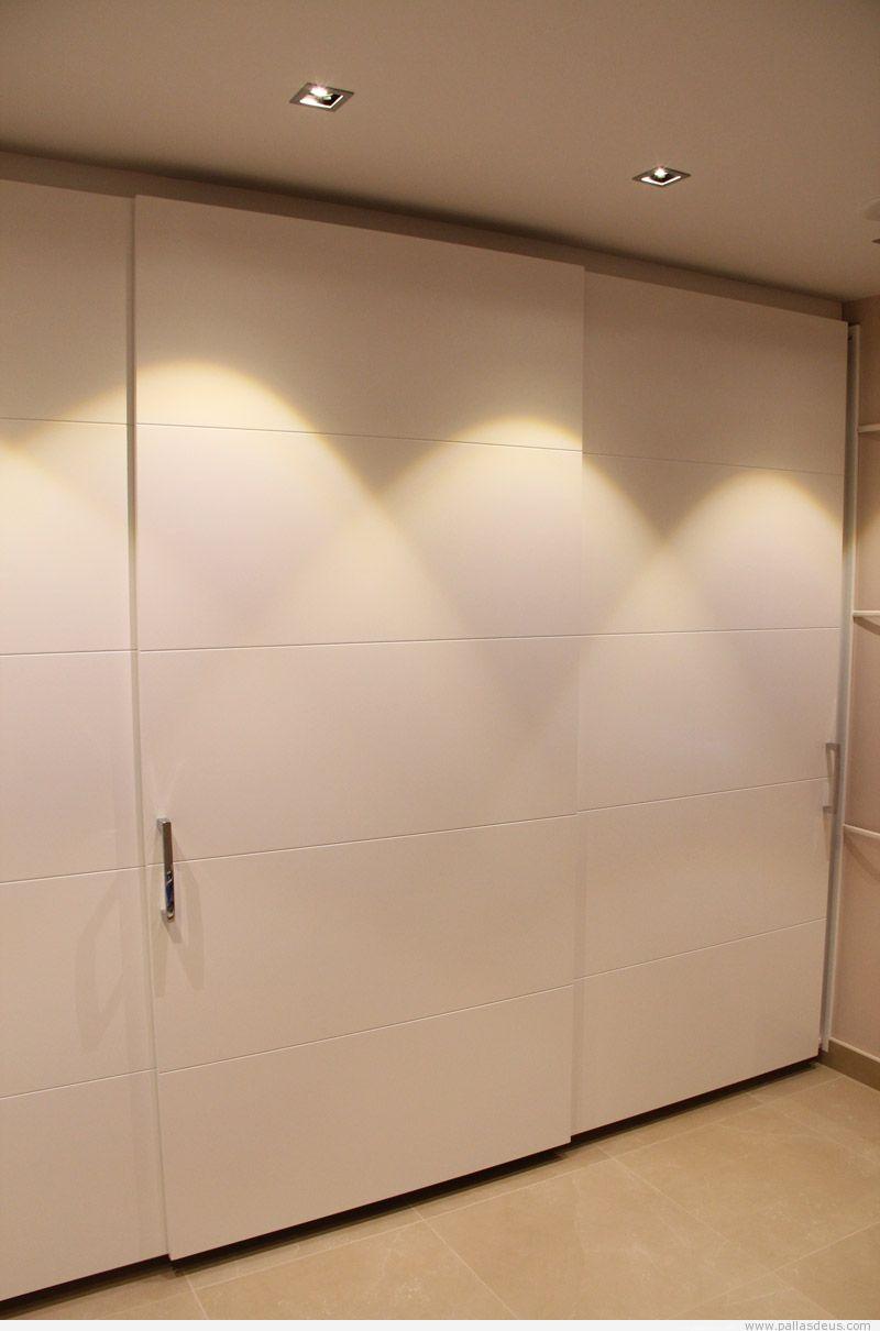 Para el armario aconsejamos un acabado lacado mate en color blanco roto, el mismo que se vaya a utilizar en las paredes, con 2 puertas correderas de apertura con uñero para que quede totalmente