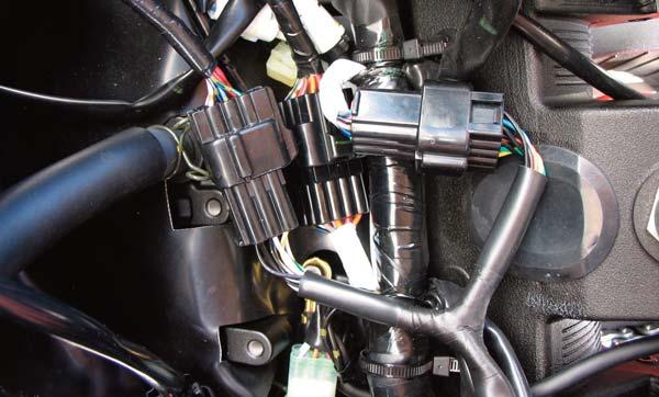 Hacer pasar el mazo de cables del PCV por el lateral izquierdo de la moto y guiarlo por debajo de la brida de sujeción del depósito de la gasolina (Fig. A).