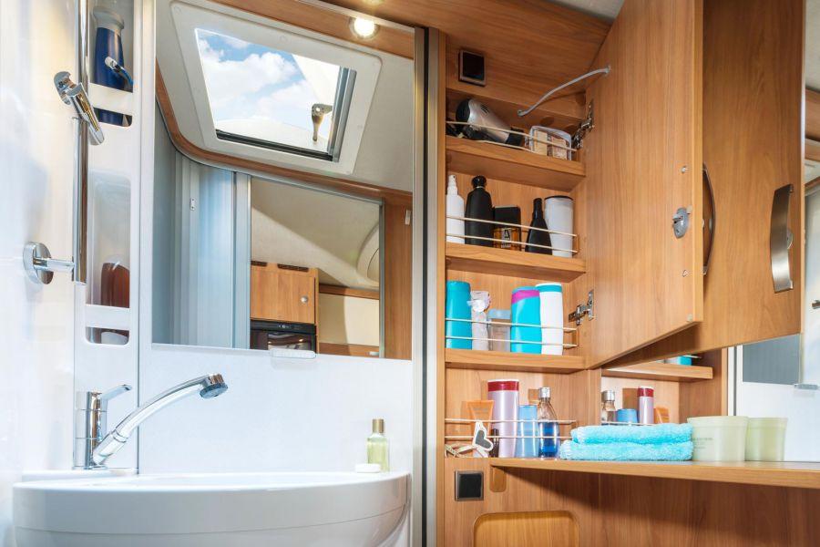 Un amplio armario de baño y numerosos estantes ofrecen un sinnúmero de opciones de almacenamiento en el baño.