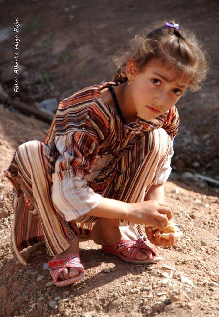 4. Una niña recoge trozos de pan del suelo, en el campo de refugiados Harsham en Erbil. Kurdistán Iraquí. Iraq 2015.