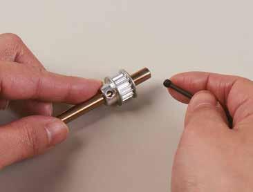 3 Inserta el tornillo en el orificio de la polea de sincronización y gíralo en el sentido de las agujas