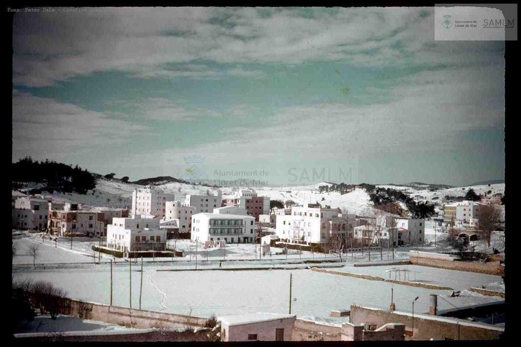En la imatge, la Rocagrossa nevada i algunes cases i pisos en primer terme com l'hotel Sant Martí i el