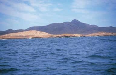 LITORAL Barrera de dunas fósiles. Al fondo, a la derecha, la puntiaguda cumbre del Atalayón (185 m).